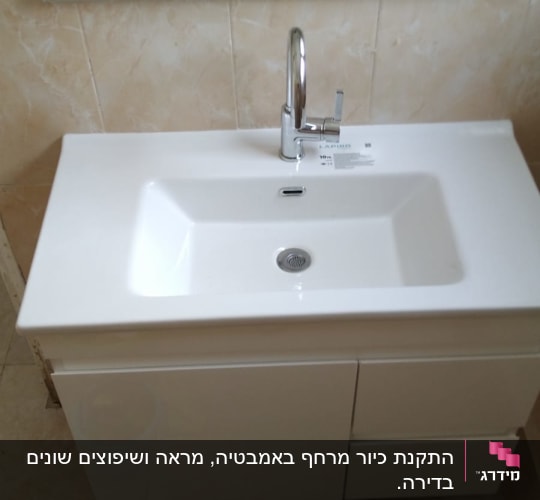כיור לבן עם ברז כרום מותקן על ארון אמבטיה